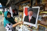 Pedagang merapikan poster Presiden Joko Widodo dan Wakil Presiden terpilih Ma'ruf Amin yang dijualnya di kawasan Pasar Sudimampir, Banjarmasin, Kalimantan Selatan, Sabtu (19/10/2019). Pedagang menjual poster tersebut dengan harga Rp5.000 tanpa pigura  sedangkan yang memakai pigura dijual dengan harga Rp30.000. Foto Antaranews Kalsel/Bayu Pratama S.