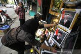 Pedagang merapikan poster Presiden Joko Widodo dan Wakil Presiden terpilih Ma'ruf Amin yang dijualnya di kawasan Pasar Sudimampir, Banjarmasin, Kalimantan Selatan, Sabtu (19/10/2019). Pedagang menjual poster tersebut dengan harga Rp5.000 tanpa pigura  sedangkan yang memakai pigura dijual dengan harga Rp30.000. Foto Antaranews Kalsel/Bayu Pratama S.