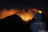 Kebakaran Gunung Ranti terlihat dari Tawonan, Taman Sari, Banyuwangi, Jawa Timur, Minggu (20/10/2019). Angin kencang yang terjadi di sekitaran Taman Wisata Alam Gunung Ijen itu, menyebabkan banyak pohon tumbang serta kebakaran di Gunung Ranti dan Gunung Widodaren semakin meluas. Antara Jatim/Budi Candra Setya/zk