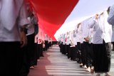 Santri membawa bendera merah putih sepanjang 1000 meter saat pawai peringatan Hari Santri Nasional di Sidoarjo, Jawa Timur, Minggu (20/10/2019). Kegiatan yang diikuti oleh ribuan santri dan guru dari berbagai sekolah dan pesantren tersebut untuk memperingati Hari Santri Nasional. Antara Jatim/Umarul Faruq/zk