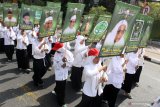 Santri membawa sejumlah poster tokoh Nahdlatul Ulama pada pawai peringatan Hari Santri Nasional di Sidoarjo, Jawa Timur, Minggu (20/10/2019). Kegiatan yang diikuti oleh ribuan santri dan guru dari berbagai sekolah dan pesantren tersebut untuk memperingati Hari Santri Nasional. Antara Jatim/Umarul Faruq/zk