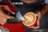 Barista membuat gambar dengan susu diatas kopi arabika pada perlombaan seni latte di Blangpadang, Banda Aceh, Aceh, Minggu (20/10/2019). Perlombaan seni latte yang dilaksanakan pada festival kopi Banda Aceh 2019 bertujuan meningkatkan kemampuan barista lokal dalam menyajikan kopi arabika gayo. Antara Aceh/Irwansyah Putra.