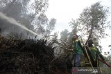 Relawan pemadam kebakaran berupaya memadamkan kebakaran lahan gambut di Kecamatan Gambut, Kabupaten Banjar, Kalimantan Selatan, Senin (21/10/2019). Akibat curah hujan yang masih rendah Kebakaran hutan dan lahan (Karhutla) masih terjadi di sejumlah wilayah Provinsi Kalsel. Foto Antaranews Kalsel/Bayu Pratama S.