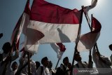 Sejumlah santri membawa bendera merah putih saat mengikuti upacara Peringatan Hari Santri Nasional Tingkat Provinsi Jawa Barat 2019 di Lapangan Gasibu, Bandung, Jawa Barat, Senin (22/10/2019). Pemerintah Jawa Barat memberikan sejumlah bantuan motor listrik dan hadiah umroh bagi santri, pondok pesantren serta DKM se-Jawa Barat pada Peringatan Hari Santri Nasional 2019 yang bertema Santri Indonesia Untuk Perdamaian Dunia. ANTARA FOTO/Novrian Arbi/agr