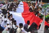 Sejumlah santri mengikuti Kirab Hari Santri Nasional 2019 di Lapang Dadaha, Kota Tasikmalaya, Jawa Barat, Selasa (22/10/2019). Kirab santri yang diikuti ribuan santri dari berbagai pondok pesantren se-Tasikmalaya dalam rangka memperingati hari santri nasional dengan menjadi momentum membangun optimisme santri Indonesia menjadi garda terdepan dalam menjaga nilai-nilai keberagamaan dan kebangsaan. ANTARA FOTO/Adeng Bustomi/agr