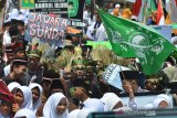 Sejumlah santri mengikuti Kirab Hari Santri Nasional 2019 di Lapang Dadaha, Kota Tasikmalaya, Jawa Barat, Selasa (22/10/2019). Kirab santri yang diikuti ribuan santri dari berbagai pondok pesantren se-Tasikmalaya dalam rangka memperingati hari santri nasional dengan menjadi momentum membangun optimisme santri Indonesia menjadi garda terdepan dalam menjaga nilai-nilai keberagamaan dan kebangsaan. ANTARA FOTO/Adeng Bustomi/agr