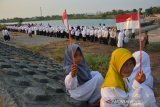 Santri dan masyarakat menggelar apel Hari Santri Nasional (HSN) 2019 di tepi Bendungan Karet atau Dam Karet Desa Jombatan, Kecamatan Kesamben, Jombang, Jawa Timur, Selasa (22/10/2019). Apel HSN 2019 di tepi Dam Karet yang digelar PCNU setempat tersebut untuk menggelorakan resolusi jihad kepada santri di era milenial. Antara Jatim/Syaiful Arif/zk.