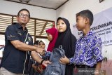 Operation Head Terminal BBM Cikampek Gatot Widiyanto (kiri) menyerahkan bantuan perlengkapan sekolah secara simbolis kepada siswa di SDN Sungai Buntu I, Karawang, Jawa Barat, Rabu (23/10/2019). Pertamina MOR III memberikan bantuan alat sekolah berupa tas ransel dan alat tulis kepada 1.032 siswa-siswi SDN Sungai Buntu I hingga SDN Sungai Buntu IV, bantuan tersebut diharapkan dapat memberikan dampak positif dan memotivasi semangat belajar untuk meraih prestasi dan mengharumkan nama sekolah serta daerahnya. ANTARA FOTO/M Ibnu Chazar. ANTARA JABAR/Muhamad Ibnu Chazar/agr