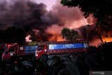 KEBAKARAN GUDANG DI SURABAYA. Petugas Dinas Pemadam Kebakaran Kota Surabaya memadamkan gudang yang terbakar di Jalan Indrapura No 32 Surabaya, Jawa Timur, Rabu (23/10/2019). Sekitar 23 kendaraan pemadam kebakaran dan dua unit Bronto Sky Lift dikerahkan untuk memadamkan kebakaran gudang yang menyimpan ban bekas dan menjadi lahan parkir truk ekspedisi serta elpiji tersebut. ANTARA FOTO/Didik SuhartonoANTARA FOTO/Didik Suhartono (ANTARA FOTO/Didik Suhartono)