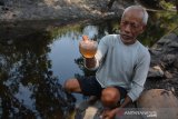 Kusnan (60) menunjukkan air sungai yang diduga tercemar limbah pabrik di Dusun Gongseng, Desa Pojokrejo, Kecamatan Kesamben, Kabupaten Jombang, Jawa Timur, Kamis (24/10/2019). Air sungai berubah warna dan mengelurkan bau yang menyengat tersebut diduga tercemar limbah pabrik kertas. Antara Jatim/Syaiful Arif/zk