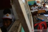  Siswa mengikuti kegiatan belajar mengajar di kelas darurat di Dusun Bendo, Desa Kumitir, Kecamatan Jatirejo, Kabupaten Mojokerto, Jawa Timur, Senin (28/10/2019). Puluhan siswa SDN II Kumitir terpaksa belajar di kelas darurat sejak sepekan lalu karena seluruh ruang kelas belum selesai rehabilitasi bagian atap. Antara Jatim/Syaiful Arif/zk