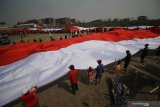 Warga membentangkan bendera Merah Putih saat memperingati Hari Sumpah Pemuda di kampung nelayan Greges, Surabaya, Jawa Timur, Minggu (27/10/2019). Peringatan Hari Sumpah Pemuda yang ke-91 di daerah tersebut dimeriahkan dengan pembacaan Ikrar Sumpah Pemuda di atas perahu, pembentangan bendera Merah Putih sepanjang 500 meter serta pentas kesenian dan berbagai perlombaan. Antara Jatim/Moch Asim//zk.