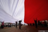 Warga membentangkan bendera Merah Putih saat memperingati Hari Sumpah Pemuda di kampung nelayan Greges, Surabaya, Jawa Timur, Minggu (27/10/2019). Peringatan Hari Sumpah Pemuda yang ke-91 di daerah tersebut dimeriahkan dengan pembacaan Ikrar Sumpah Pemuda di atas perahu, pembentangan bendera Merah Putih sepanjang 500 meter serta pentas kesenian dan berbagai perlombaan. Antara Jatim/Moch Asim/zk.