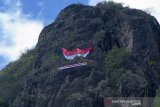 Pemanjat memasang bendera raksasa berukuran 30 x 20 meter di tebing Gunung Spikul, Trenggalek, Jawa Timur, Senin (28/10/2019). Pengibaran bendera raksasa di ketinggian sekitar 380 meter di atas permukaan tanah, itu dilakukan komunitas Federasi Pemanjat Tebing Indonesia (FPTI) dan diikuti seluruh perwakilan mahasiswa pecinta alam dari berbagai daerah di Indonesia dalam rangka peringatan Hari Sumpah Pemuda ke-91. Antara Jatim/Destyan Sujarwoko/zk