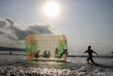 Sejumlah anak bermain bola air raksasa di Pantai Gemah, Tulungagung, Jawa Timur, Minggu (27/10/2019). Pantai yang terletak di pesisir selatan Tulungagung bagian barat itu ramai dikunjungi wisatawan seiring pembangunan akses Jalur Lintas Selatan. Antara Jatim/Umarul Faruq/zk