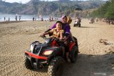 Wisatawan menaiki motor ATV di Pantai Gemah, Tulungagung, Jawa Timur, Minggu (27/10/2019). Pantai yang terletak di pesisir selatan Tulungagung bagian barat itu ramai dikunjungi wisatawan seiring pembangunan akses Jalur Lintas Selatan. Antara Jatim/Umarul Faruq/zk