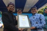 Bupati Banyuwangi Abdullah Azwar Anas (Kanan) menerima piagam Museum Rekor Dunia Indonesia oleh Senior Maneger MURI Yusuf Ngadri bersama di Gasibu, Banyuwangi, Jawa Timur, Senin (28/10/2019). Kegiatan belajar bersama peserta kejar paket C dan B yang diikuti 2.150 peserta itu, memecahkan rekor MURI sebagai peserta belajar daring terbanyak. Antara Jatim/Budi Candra Setya/zk.