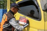 Petugas Dinas Perhubungan memasang stiker kendaraan yang overload saat penertiban muatan Operasi Zebra Semeru 2019 di tol Sidoarjo, Jawa Timur, Selasa (29/10/2019). Penertiban muatan dalam Operasi Zebra Semeru tersebut bertujuan untuk menekan angka kecelakaan lalu lintas yang diakibatkan oleh beratnya muatan barang yang tidak sesuai dengan kapasitas kendaraan. Antara Jatim/Umarul Faruq/zk