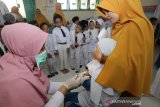Petugas pusat kesehatan masyarakat (Puskesmas) Ulee Kareng (kiri) memberikan imunisasi vaksin difteri, campak rubella dan vaksin tetanus pada pelajar di Madrasah Ibtidaiyah Negeri (MIN) V,  Banda Aceh, Aceh, Selasa (29/10/2019). Pemberian vaksin difteri, campak rubella dan vaksin tetanus pada pelajar dilakukan untuk mencegah para siswa terjangkit berbagai virus penyakit. Antara Aceh/Irwansyah Putra.
