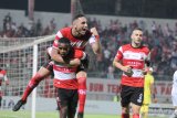 Pesepak bola Madura United (MU) Greg Nwokolo menggendong Jaimerson da Silva Xavier dan Aleksandar Rakic (kanan) melakukan selebrasi usai mencetak gol ke gawang PS Tira Persikabo dalam laga Shopee Liga 1 di Stadion Gelora Bangkalan (SGB) Bangkalan, Jawa Timur, Rabu (30/10/2019). MU memenangi pertandingan tersebut dengan skor 1-0. Antara Jatim/Saiful Bahri/zk.