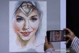 Pengunjung mengamati lukisan yang dipajang pada pameran lukisan bertema 'Women In Art' di Galeri Prabangkara, Surabaya, Jawa Timur, Kamis (31/10/2019). Sekitar 154 lukisan karya tiga perupa bernama Andreanus Gunawan, Budi Bi dan Taufik Kamajaya tersebut berlangsung sampai 2 Nopember 2019. Antara Jatim/Didik Suhartono/ZK