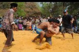 Peserta gulat tradisional Madura (Okol) berusaha saling membanting saat pertandingan, di Desa Akkor, Pamekasan, Jawa Timur, Jumat (1/11/2019). Tradisi yang digelar tiap akhir musim kemarau itu sebagai permohonan kepada Tuhan agar turun hujan. ANTARA FOTO/Saiful Bahri/nym