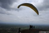 Seorang atlet bersiap lepas landas saat mengikuti kejuaraan paralayang Piala Bupati Jember di Bukit Mandigu, Desa Suco, Mumbulsari, Jember, Jawa Timur, Sabtu (2/11/2019). Kejuaraan paralayang tersebut diikuti 89 peserta dari sejumlah provinsi untuk kategori ketepatan mendarat. Antara Jatim/Seno/zk.