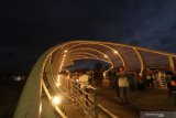 Wisatawan menikmati suasana jembatan lintas di Pantai Marina Boom, Banyuwangi, Jawa Timur, Minggu (3/11/2019). Pantai Boom yang akan digunakan sebagai dermaga kapal pesiar itu, mulai ramai dikunjungi wisatawan. Antara Jatim/Budi Candra Setya/zk.