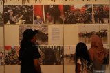 Pengunjung melihat karya foto yang dipamerkan di Gedung Wanita, Banyuwangi, Jawa Timur, Minggu (3/11/2019). Pameran foto dengan tema 
