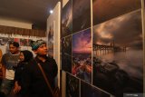 Pengunjung melihat karya foto yang dipamerkan di Gedung Wanita, Banyuwangi, Jawa Timur, Minggu (3/11/2019). Pameran foto dengan tema 