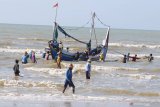 Nelayan bergotong royong menyelamatkan perahu yang karam saat akan melaut akibat angin kecang dan ombak di Pantai Jumiang, Pamekasan, Jawa Timur, Selasa (5/11/2019). BMKG menghimbau untuk mewaspadai    kecepatan angin di Laut Jawa bagian timur yang mencapai 19 knots (35 km/jam) dan ketinggian gelombang 2.5 meter. Antara Jatim/Saiful Bahri/zk