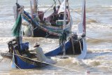 Nelayan berada di atas perahu yang karam saat akan melaut akibat angin kecang dan ombak di Pantai Jumiang, Pamekasan, Jawa Timur, Selasa (5/11/2019). BMKG menghimbau untuk mewaspadai    kecepatan angin di Laut Jawa bagian timur yang mencapai 19 knots (35 km/jam) dan ketinggian gelombang 2.5 meter. Antara Jatim/Saiful Bahri/zk