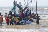 Nelayan bergotong royong menyelamatkan perahu yang karam saat akan melaut akibat angin kecang dan ombak di Pantai Jumiang, Pamekasan, Jawa Timur, Selasa (5/11/2019). BMKG menghimbau untuk mewaspadai    kecepatan angin di Laut Jawa bagian timur yang mencapai 19 knots (35 km/jam) dan ketinggian gelombang 2.5 meter. Antara Jatim/Saiful Bahri/zk