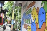 Warga melintas di dekat mural kampung warna-warni tanpa rokok di Jakarta, Rabu (6/11/2019). Kampung Penas Tanggul warna-warni menjadi kampung percontohan sebagai kampung sehat tanpa asap rokok untuk melindungi hak hidup sehat bagi perempuan dan anak-anak. ANTARA FOTO/Nova Wahyudi/nym.