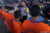 Kapolres Kediri AKBP Roni Faisal Saiful Faton (kanan) memperlihatkan sejumlah tersangka pejudi saat rilis ungkap kasus perjudian pemilihan kepala desa (pilkades) di Polres Kediri, Jawa Timur, Rabu (6/11/2019). Kepolisian daerah setempat membentuk satgas anti botoh guna menangkal praktik perjudian yang biasanya marak saat penyelenggaraan pilkades serentak. Antara Jatim/Prasetia Fauzani/zk