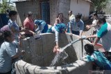 Siswa menyalurkan bantuan air bersih dalam bak penampungan sementara di Desa Demuk, Tulungagung, Jawa Timur, Rabu (6/11/2019). Bantuan itu merupakan hasil patungan siswa dan guru setempat untuk memenuhi kebutuhan air bersih warga yang terdampak kekeringan parah selama dua bulan terakhir. Antara Jatim/Destyan Sujarwoko/zk