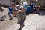 Warga menggendong galon yang telah terisi air bersih bantuan siswa di Desa Demuk, Tulungagung, Jawa Timur, Rabu (6/11/2019). Bantuan itu merupakan hasil patungan siswa dan guru setempat untuk memenuhi kebutuhan air bersih warga yang terdampak kekeringan parah selama dua bulan terakhir. Antara Jatim/Destyan Sujarwoko/zk