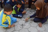 Murid SD bermain dakon saat mengikuti Festival Permainan Tradisional Anak-2019 di SDN Ringinagung, Magetan, Jawa Timur, Kamis (7/11/2019). Festival Permainan Tradisional Anak bertema Sehari Belajar di Luar Kelas meliputi lompat tali, gobak sodor, egrang, dakon, bekelan, bentengan dan engklek tersebut dimaksudkan untuk memperkenalkan dan mengakrabkan kembali permainan tradisional yang mulai banyak dilupakan kepada anak. Antara Jatim/Siswowidodo/zk.
