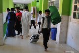 Santri membawa perlengkapan harian untuk dibawa pulang saat  libur Maulid di Pondok Pesantren  Tahfidz Al Quran Al Amin, Sumenep, Jawa Timur, Kamis (7/11/2019). Dalam kalender pendidikan pesantren yang dikenal hingga negara negata tetangga itu,  menetapkan dua kali liburan yaitu libur Maulid dan Ramadhan. Antara Jatim/Saiful Bahri/zk.