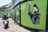 Pejalan kaki melintas di depan mural pahlawan nasional di Jalan Veteran Dalam, Malang, Jawa Timur, Kamis (7/11/2019). Warga setempat sengaja melukis mural di dinding tersebut untuk menghilangkan kesan kumuh sekaligus menanamkan rasa patriotisme pada masyarakat menjelang peringatan Hari Pahlawan. Antara Jatim/Ari Bowo Sucipto/zk.