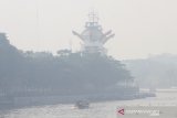 Kelotok (perahu bermesin) melintas di Sungai Martapura yang di selimuti kabut asap di Kota Banjarmasin, Kalimantan Selatan, Jumat (8/11/2019). Kebakaran hutan dan lahan (Karhutla) yang kembali terjadi di sejumlah daerah di Provinsi Kalsel menimbulkan kabut asap hingga menyelimuti Kota Banjarmasin. Foto Antaranews Kalsel /Bayu Pratama S.