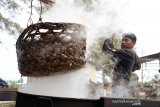 Perajin memindahkan keranjang berisi ikan tongkol seusai direbus saat proses pengeringan menggunakan panas matahari di salah satu usaha industri rumahan, Desa Gano, Kecamatan Syiah Kuala, Banda Aceh, Aceh, Jumat (8/11/2019). Menurut perajin, dampak dari perubahan cuaca yang memasuki musim penghujan, pmengakibat roduksi ikan kayu saat ini menurun dari empat ton menjadi tiga ton perbulan dengan harga penjualan Rp30.000 perkilogram. Antara Aceh/Ampelsa.