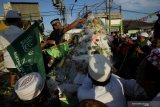 Warga berebut gunungan berupa buah dan sayur saat mengikuti pawai Maulid Nabi di Kampung Nelayan Nambangan-Cumpat, Surabaya, Jawa Timur, Jumat (8/11/2019). Pawai yang diikuti oleh ratusan murid dan guru Taman Pendidikan Al Quran (TPA) serta warga kampung nelayan tersebut dalam rangka memperingati hari lahirnya Nabi Muhammad SAW. Antara Jatim/Moch Asim/zk.