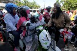 Komunitas Pecinta Kereta Api memberikan bendera Merah Putih kepada pengguna jalan saat sosialisasi disiplin berlalu lintas di perlintasan kereta api, di Jalan A Yani, Surabaya, Jawa Timur, Minggu (10/11/2019). Sosialisasi yang digelar PT Kereta Api Indonesia (KAI) Daop 8 Surabaya dengan membagikan stiker himbauan, bendera Merah Putih serta bunga itu bertujuan memberikan pemahaman kepada masyarakat untuk berhati-hati ketika melintas di perlintasan kereta api. Antara Jatim/Didik S/ZK