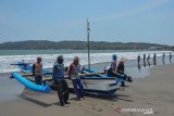 Sejumlah nelayan bergotong royong mendorong perahu berkapasitas 7 Gross Tonnage (GT) di Pesisir Pantai Timur Pangandaran, Jawa Barat, Senin (11/11/2019). Kementerian Kelautan dan Perikanan mendorong pemilik kapal untuk mengasuransikan anak buah kapal (ABK) dengan menargetkan 160.000 fasilitasi asuransi untuk nelayan kecil atau kapal di bawah 10 GT, sedangkan sampai saat tercatat hanya 88.000 nelayan yang disetujui asuransinya. ANTARA JABAR/Adeng Bustomi/agr