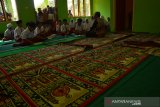 Siswa kelas 5 mengikuti proses belajar di musala Sekolah Dasar Negeri Dukuh Klopo, Kecamatan Peterongan, Kabupaten Jombang, Jawa Timur, Selasa (12/11/2019). Pasca salah satu ruang kelas SDN Dukuh Klopo, ambruk lantaran usia bangunan yang cukup tua serta sudah lapuk. Siswa kelas 5 dan 2 harus belajar secara lesehan di ruang perpustakaan serta musala karena pihak sekolah khawatir, ruang kelas 2 dan 5 ikut terdampak sebab ruangannya berada di sebelah bangunan yang ambruk. Antara Jatim/Syaiful Arif/zk