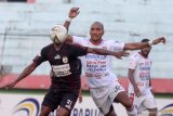 Pesepak bola Persipura Yustinus Pae (kedua kiri) mendapat hadangan pesepak bola Bali United Leonard Tupamahe (kedua kanan) pada lanjutan Liga 1 2019 di Stadion Gelora Delta Sidoarjo, Jawa Timur, Senin (11/11/2019). Persipura bermain imbang melawan Bali United dengan skor akhir 2-2. Antara Jatim/Umarul Faruq/zk