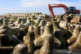 Sejumlah pekerja melakukan pemasangan batu pemecah ombak saat pembangunan tanggul pengaman pantai di Desa Suak Timah, Kecamatan Samatiga, Aceh Barat, Selasa (12/11/2019). Pembangunan tanggul pengaman pantai tersebut untuk mengatasi penurunan permukaan tanah di sepanjang pantai sekaligus untuk memajukan perekonomian masyarakat pesisir baik dari sektor pendapatan nelayan, wisata serta pengelolaan sumber daya alam ekosistem pantai. Antara Aceh/Syifa Yulinnas.