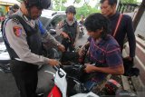 Polisi bersenjata memeriksa barang bawaan warga yang akan masuk ke Polda Jawa Timur, Surabaya, Jawa Timur, Rabu (13/11/2019). Polda Jawa Timur meningkatkan pengamanan dengan melakukan pemeriksaan terhadap barang bawaan maupun mobil milik warga yang masuk ke Polda Jawa Timur pascaledakan bom di Polrestabes Medan, Sumatera Utara. Antara Jatim/Didik S/ZK