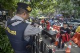 Petugas Kepolisian meminta pengunjung untuk menunjukan isi tas nya sebelum memasuki Polrestabes Bandung, Jawa Barat, Rabu (13/11/2019). Polrestabes Bandung memperketat pengamanan pascaledakan bom bunuh diri di mapolrestabes Medan pada Rabu pagi. ANTARA FOTO/Raisan Al Farisi/agr